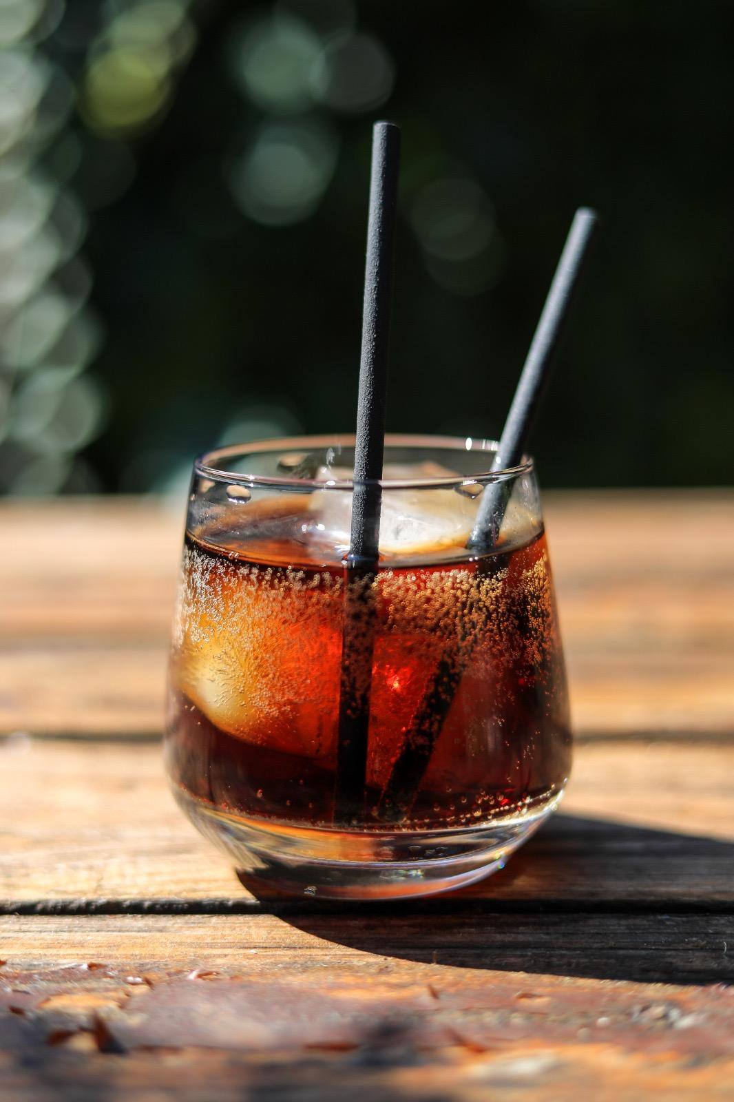 Black compostable Euro Straws in a short glass